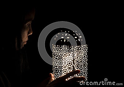 Young mixed race boy playing with lantern filled with colourful lights Stock Photo