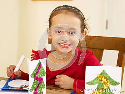 Young mixed race child making Christmas cards Stock Photo