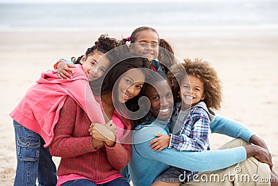 Young mixed race family embracing on beach Stock Photo