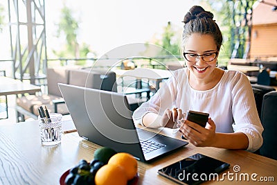 Young mixed race woman working with laptop in cafe at tropical location. Asian caucasian female studying using internet Stock Photo