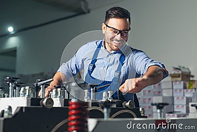 Modern industrial machine operator working in factory. Worker on the machine Stock Photo