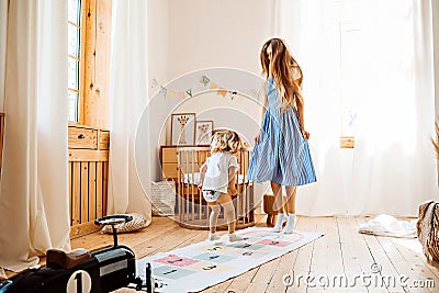 Young mom or babysitter playing with little girl at home Stock Photo