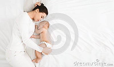 Young mom and her cute baby sleeping in bed Stock Photo