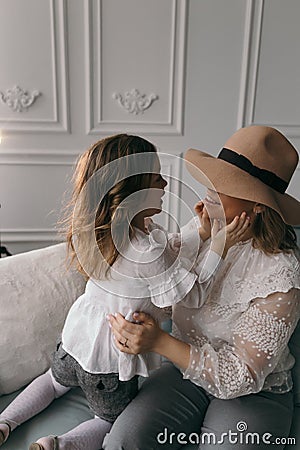 Mom and daughter in white blouses playing in the studio with daffodils. mother`s day Stock Photo