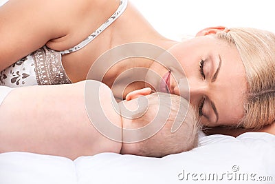 Young mom lying in bed with baby Stock Photo