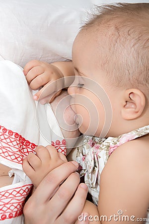 Young mother breastfeeds her baby. Stock Photo