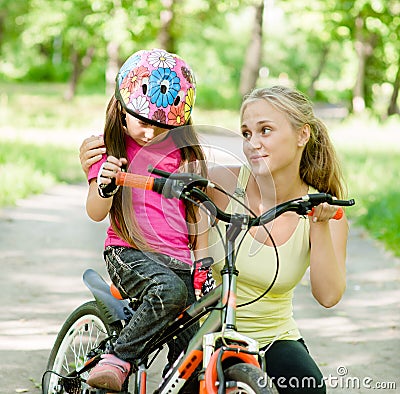 Young mother calms the sad daughter who did not get to ride a bike Stock Photo