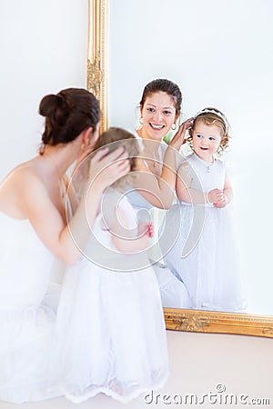 Young mother and curly daughter in front of mirror Stock Photo