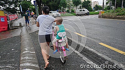 The young mother cycled her child down the road Editorial Stock Photo