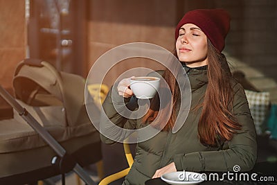 Young mother drinks coffee outdoor Stock Photo