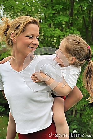 Young mother giving her child piggyback ride Stock Photo