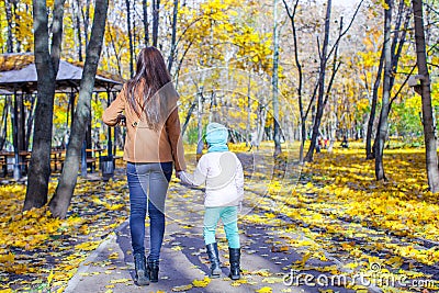 Young mother and her adorable daughter walking in Stock Photo