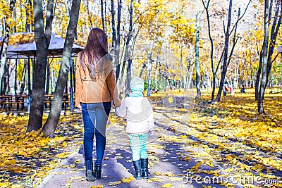 Young mother and her adorable daughter walking in Stock Photo