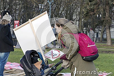 Young mother with her child in baby buggy and NO FUR sign placard at the march for Animal Advocacy in Riga, Latvia, Europe Editorial Stock Photo