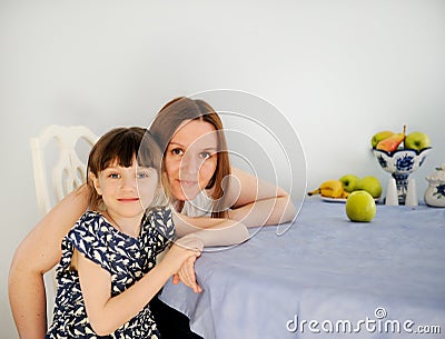 Young mother with her little daughter in kitchen Stock Photo