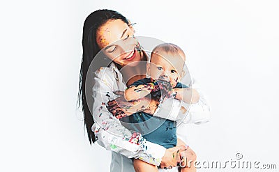 Young mother holding her newborn child. Baby soiled by paints with mother. Mom hugging and carrying her baby boy. Close Stock Photo