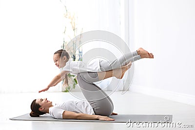 Young mother with little daughter practicing yoga Stock Photo