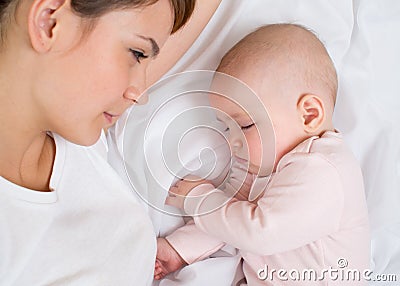 Young mother looking at her sleeping baby girl Stock Photo