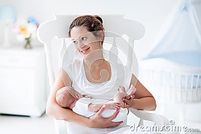 Young mother and newborn baby in white bedroom Stock Photo