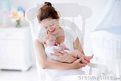 Young mother and newborn baby in white bedroom Stock Photo