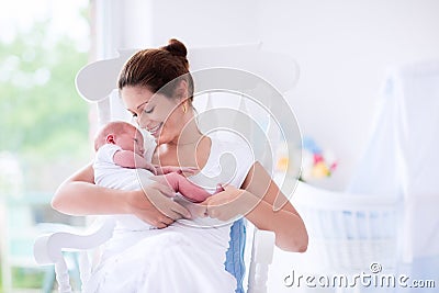 Young mother and newborn baby in white bedroom Stock Photo