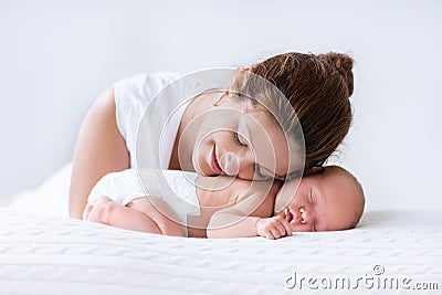 Young mother and newborn baby in white bedroom Stock Photo