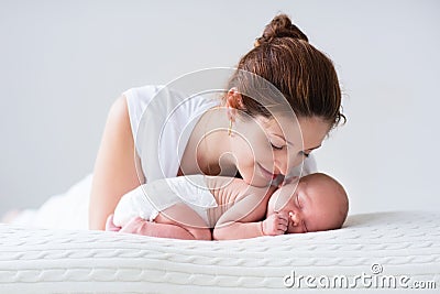 Young mother and newborn baby in white bedroom Stock Photo