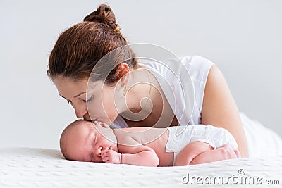 Young mother and newborn baby in white bedroom Stock Photo