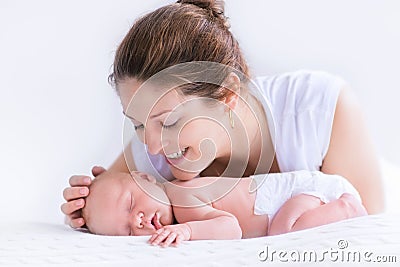 Young mother and newborn baby in white bedroom Stock Photo