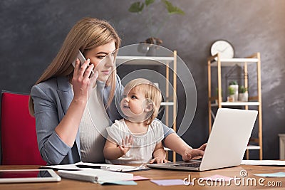 Young mother talking on phone and spending time with baby Stock Photo