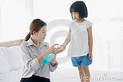 Asian Young mother washes her little girl`s hand by using a hand wash sanitizer gel. In the epidemic virus situation Stock Photo