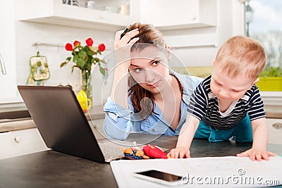 Young mother working with her baby Stock Photo