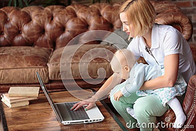 Young mother working at home with baby girl Stock Photo