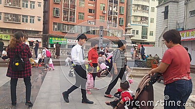 Shenzhen, China: Young mothers or grandmothers play outdoors with their children Editorial Stock Photo