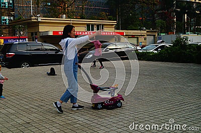 Shenzhen, China: Young mothers or grandmothers play outdoors with their children Editorial Stock Photo