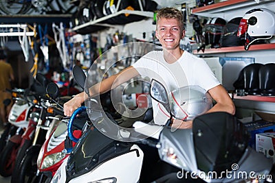 Young motorcyclist holding motorbike with helmet Stock Photo