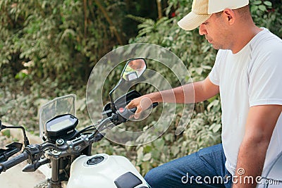 Young motorcyclist lighting up a motorcycle in the open air Stock Photo