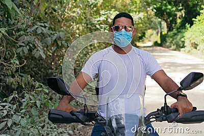 Young motorcyclist with protective mask driving a motorcycle Stock Photo