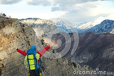Young mountaineer standing with backpack on top of a mountain Stock Photo
