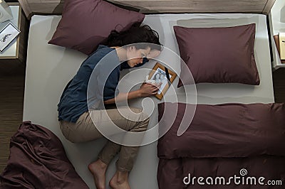 Young mourning woman lying in bed Stock Photo