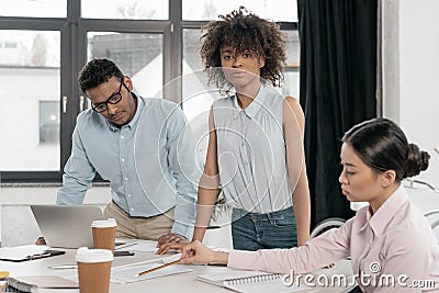 Young multiethnic businesspeople doing paperwork at office Stock Photo