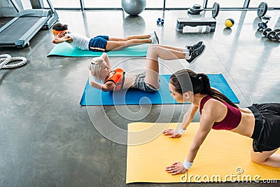 young multiethnic sportswomen exercising on fitness mats Stock Photo