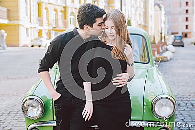 Young multiracial couple, male and female lovers heterosexual people students. Beautiful models posing standing near a retro car Stock Photo