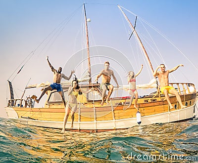 Young multiracial friends jumping from wooden sailboat Stock Photo