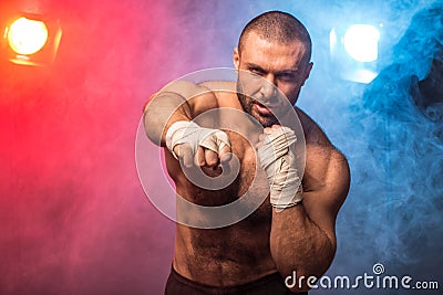 Young muscular boxing fighter training kicks. Kickboxer making a fighting exercise Stock Photo