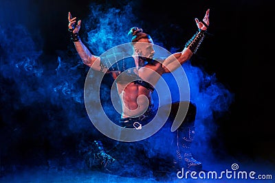 Young and muscular man performing a theatrical pose on stage. Stock Photo