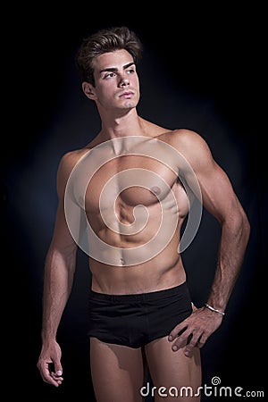 Young muscular man in underwear with a black background Stock Photo