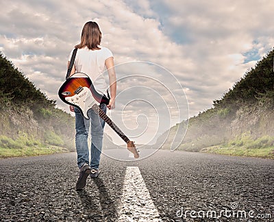 Young musician woman walking on a road Stock Photo