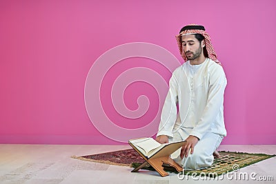 Young muslim man reading Quran during Ramadan Stock Photo