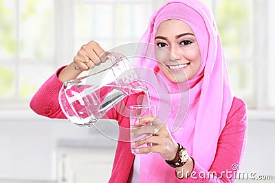 Young muslim woman pouring water into a glass Stock Photo